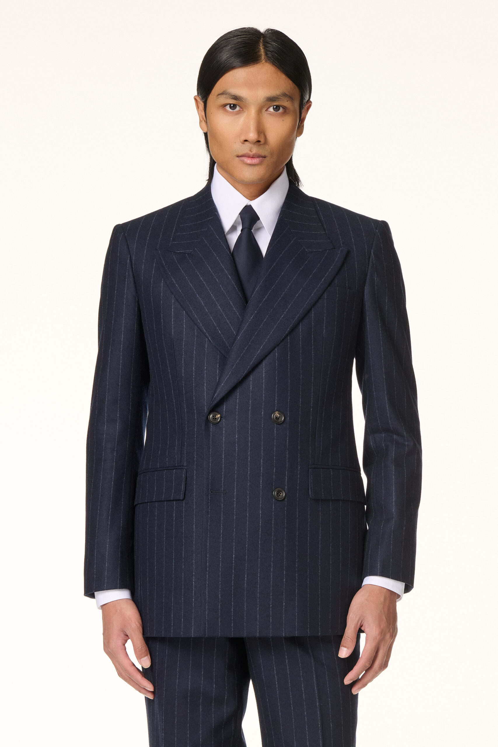 Homme en costume croisé bleu marine à fines rayures, vu de trois quarts, la ligne de côté et la taille de la veste nettement dessinées, RIVES Paris